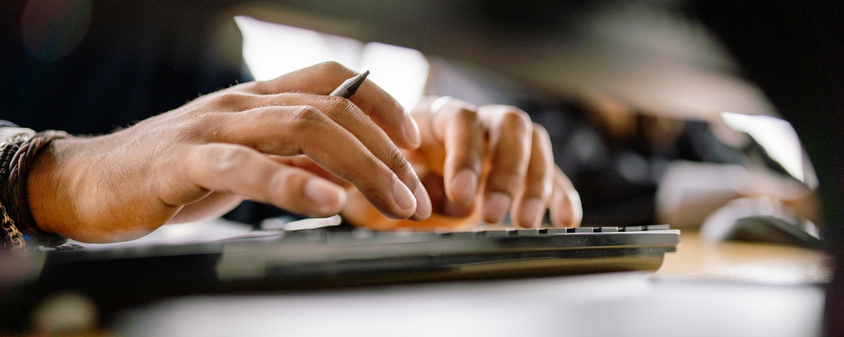 close up of hands typing on computer keyboard